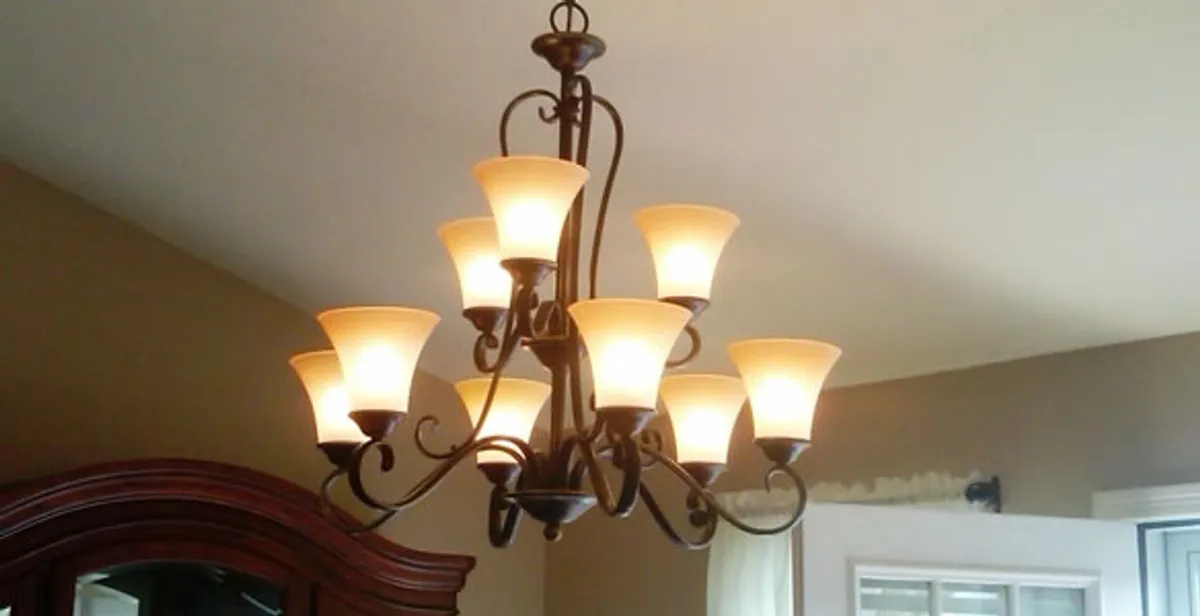 Classic ceiling chandelier installation with warm lighting in Boston, MA