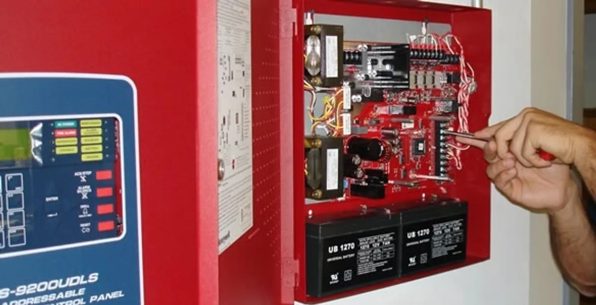 fire alarm installation service showing technician configuring fire alarm control panel in Boston, MA