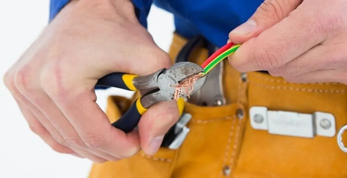 licensed electrician securing electrical wiring with professional tools during service work in Boston, MA