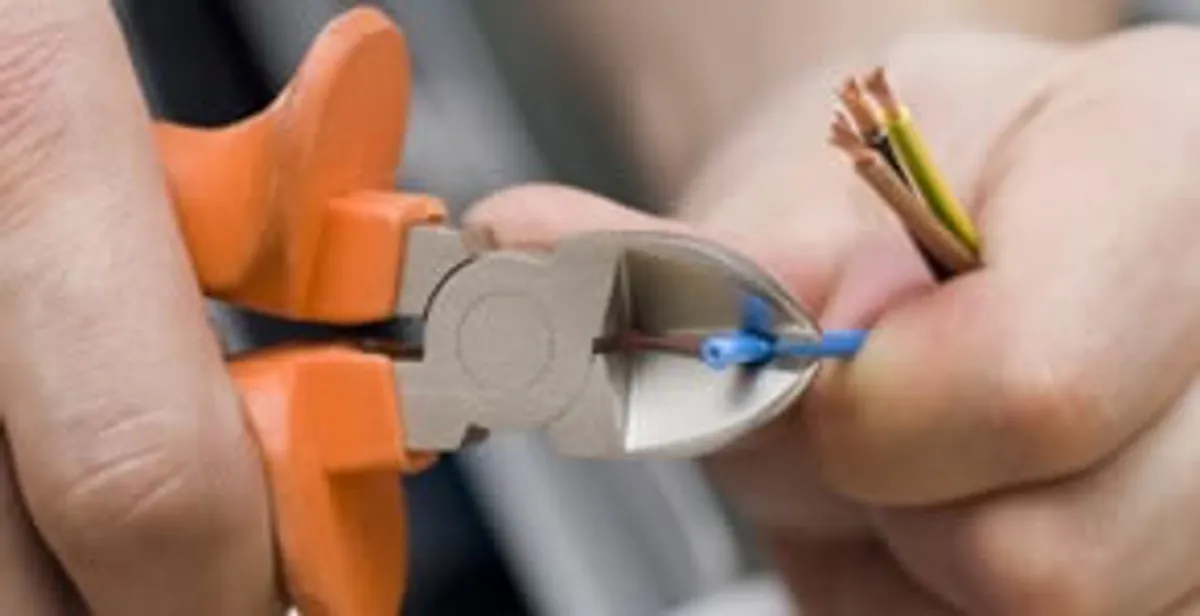 licensed electrician performing precise wire cutting and preparation during electrical service in Boston, MA