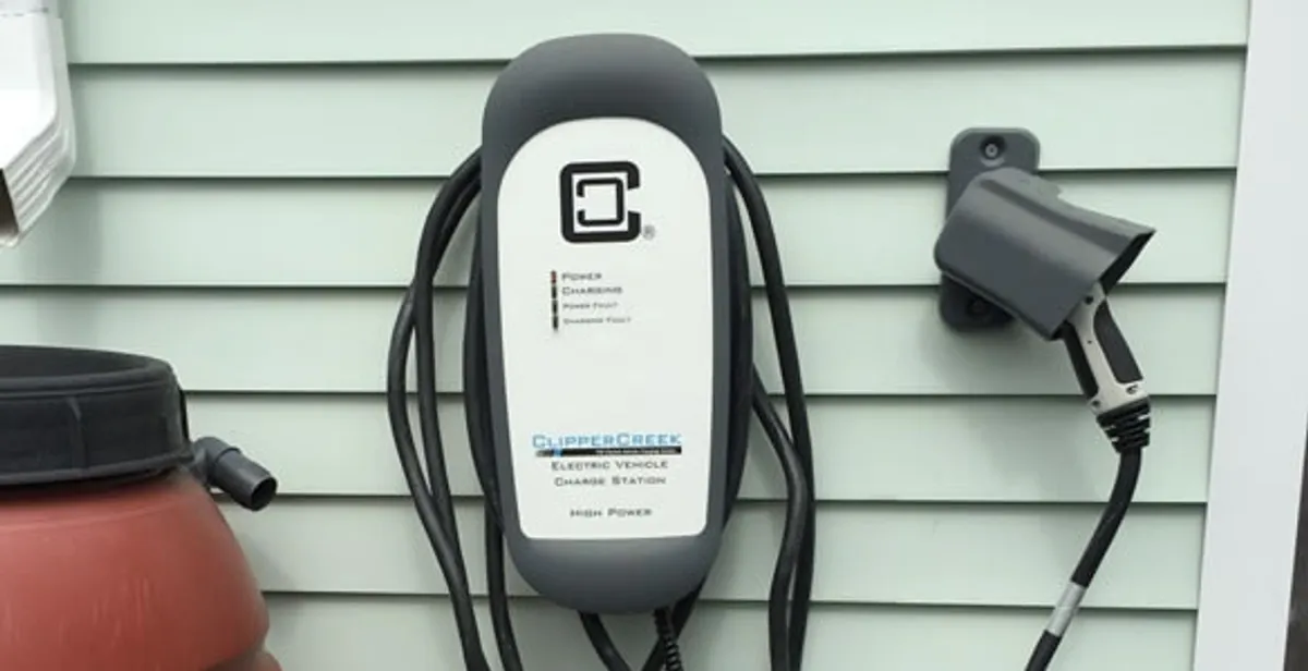 Outdoor electric vehicle charger installation on residential wall in Boston, MA